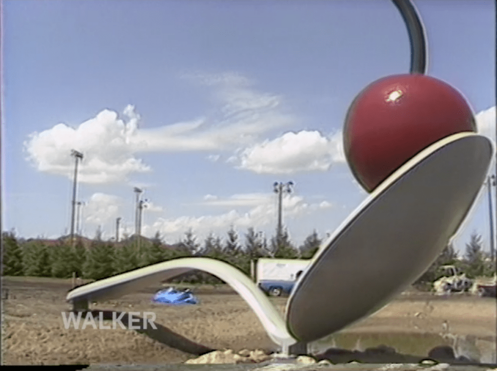 Still from U-matic tape digitized by BAVC PReservation of the 1988 installation of Spoonbridge and Cherry at the Walker Art Center
