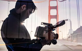 Two images are overlayed: a person recording with a video camera and a view of the golden gate bridge